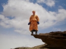 monk standing on the edge of a cliff