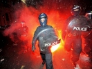 riot police walking with fire behind 1024x768