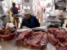 market meat on counter in market stern stall owner reading paper p1000668 b
